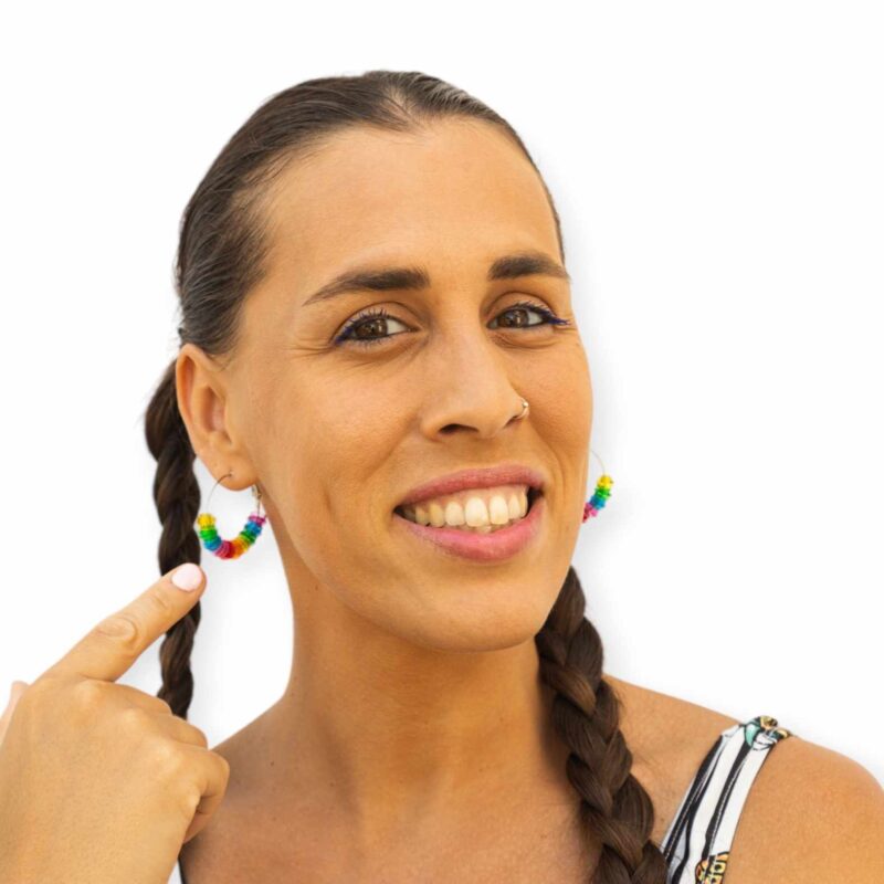 girl wearing and showing her transparent lego hoop earrings in rainbow colors