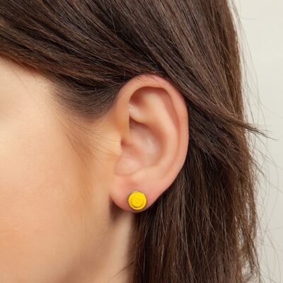 woman wearrings lego stud earrings yellow