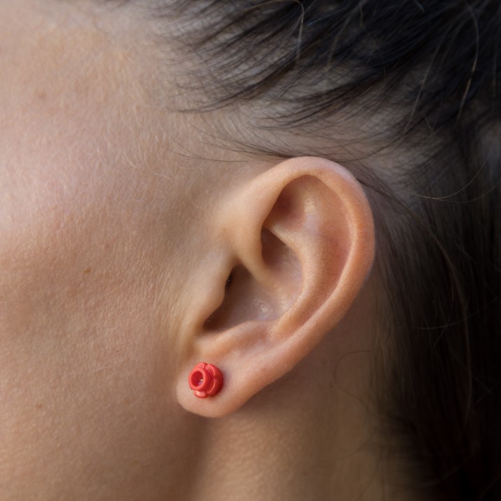 woman wearing think bricks stud flower mini earring red color