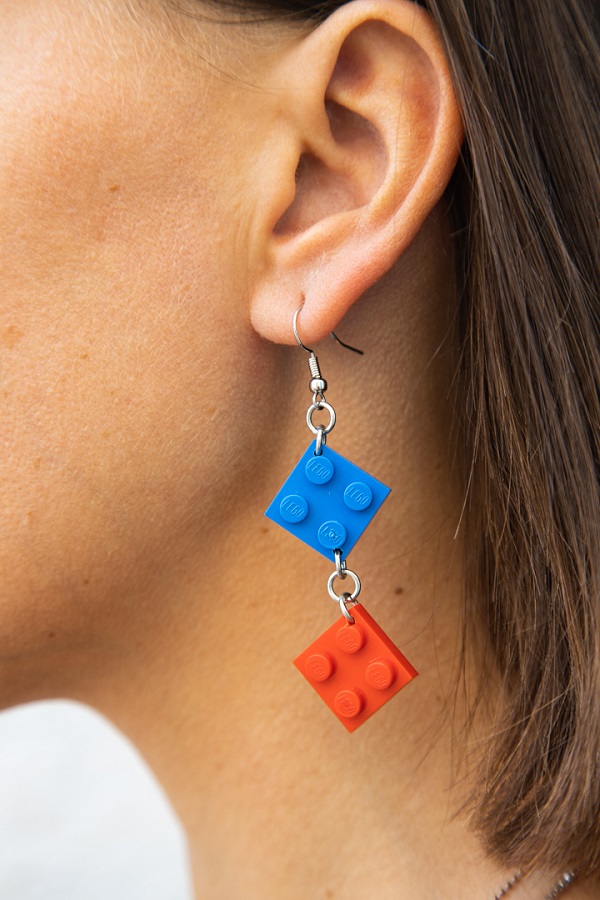 Woman (ear close up) wearing a cool drop lego earring blue and red