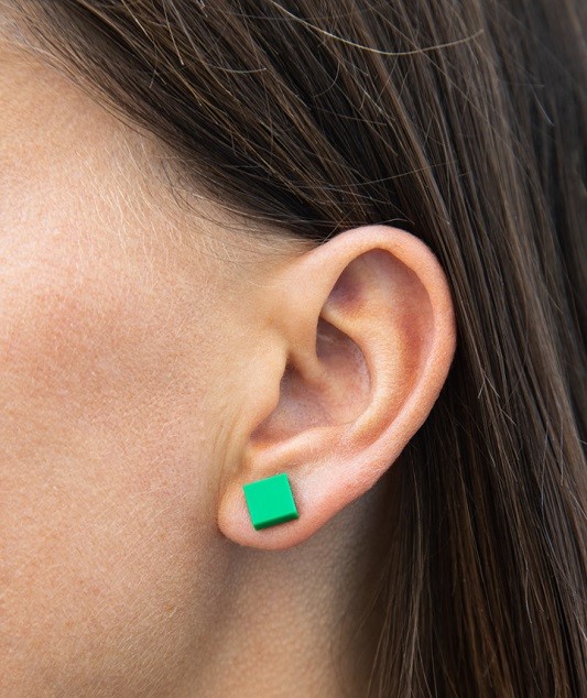 Woman wearing think bricks square lego earrings, color green
